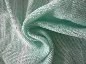 Close-up of mint green Turkish bath towel fabric showing detailed waffle weave texture