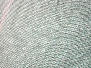 Macro view showing the detailed woven texture and soft mint green fabric of a beach towel