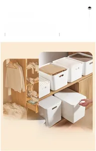 Detail of stackable white plastic storage bins with handles for cabinet organization