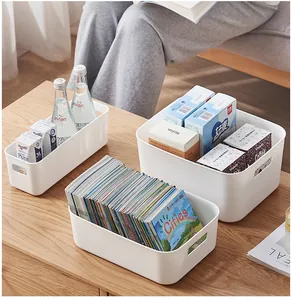 Three white plastic storage bins with handles for home organization on a wooden table