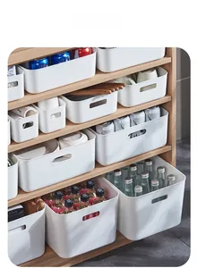Close-up of white plastic storage bins on wooden shelves for kitchen pantry organization