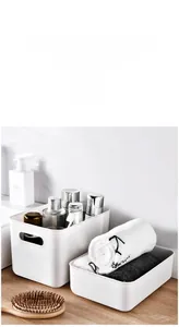 Detail view of white plastic storage bins with handles for bathroom organization