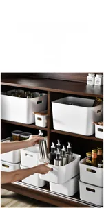 Close-up of durable white storage boxes with handles organized in a wooden cabinet
