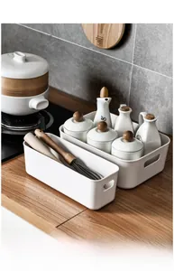 Detail view of white plastic storage bins with handles on a kitchen countertop