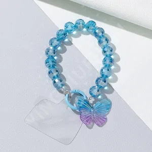 Detail of blue faceted bead phone strap with gradient butterfly pendant and metal ring