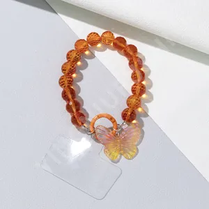 Detail of orange beaded phone charm with iridescent butterfly pendant and lobster clasp