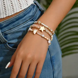 Detailansicht von Perlenarmbändern mit Seestern-Anhänger und Perlenakzenten am Handgelenk