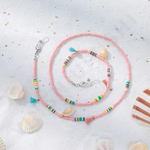 Détail de la chaîne à lunettes en perles roses avec pompons et coquillages naturels