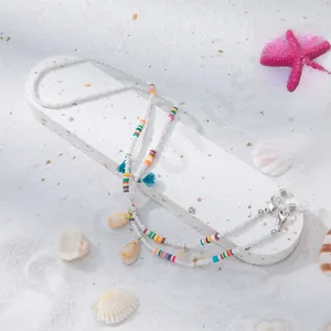 Détail de la chaîne à lunettes avec perles colorées, pendentif coquillage et pompons