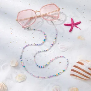 Detail der bunten Perlen-Brillenkette mit Goldherz-Anhänger auf rosa Sonnenbrille