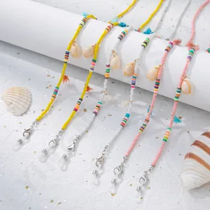 Détail de chaînes de lunettes en perles colorées avec coquillages et glands décoratifs