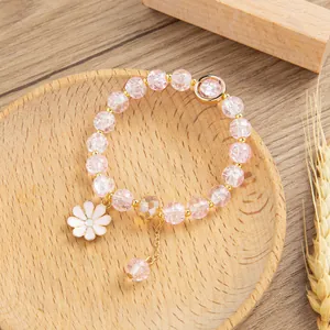 Dettaglio del bracciale di quarzo rosa craquelé con ciondolo a margherita in smalto bianco