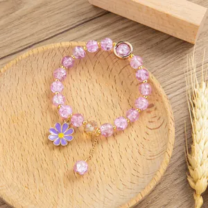 Dettaglio macro di perline di cristallo viola e ciondolo a margherita sul bracciale