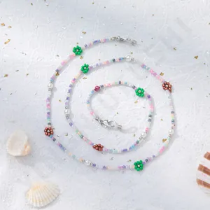 Makro-Detail einer bunten Brillen-Perlenkette mit kleinen Blumen und silbernen Karabinern