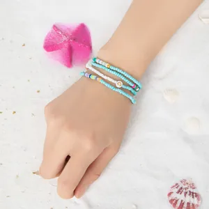 Nahaufnahme von Boho Perlenarmband-Set auf Sand mit Seesternen und Muscheln Dekoration