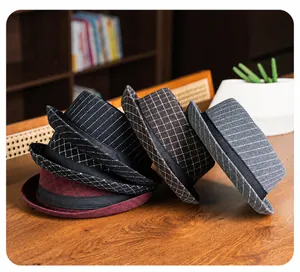 Detail of wool fedora hats with plaid patterns on a warm rustic wooden background