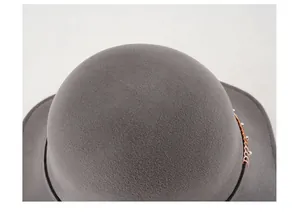 Dettaglio ravvicinato di cappello in feltro di lana grigio con catena metallica decorativa