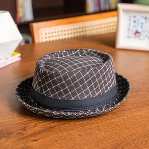 Classic brown plaid bowler hat with black ribbon on a warm wooden tabletop