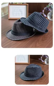 Detail of vintage fedora hats in plaid and pinstripe patterns on a wooden desk