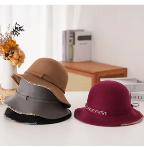 Dettaglio cappelli cloche in lana color cammello e bordeaux con cuciture fini
