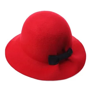 Detail of red wool felt hat featuring a stylish black bow ribbon decoration on side