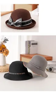 Dettagli di cappelli cloche in lana con fiocco di raso e decoro a catena metallica