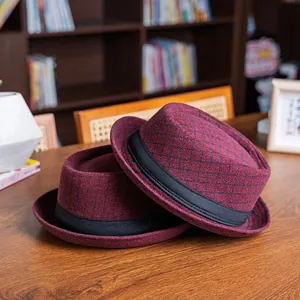 Detail of burgundy wool fedora hats with plaid pattern and black grosgrain ribbon trim