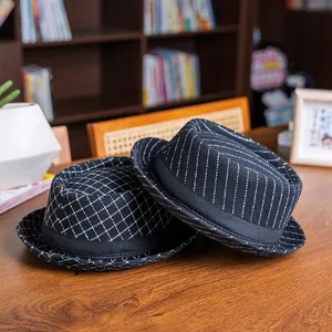 Macro detail of vintage plaid and striped fedora hats on a wooden desk setup