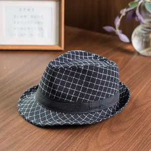 British style black plaid wool fedora hat with elegant ribbon on a wooden table