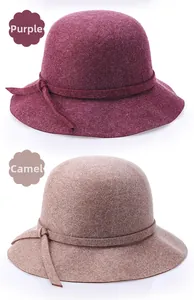 Detail of wool cloche hats in purple and camel colors with decorative knot accents