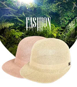 Detail of hand-woven straw hat texture with metallic M logo in beige and pink colors