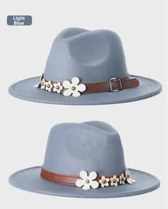 Dettaglio cappello fedora azzurro con fascia marrone, fiori bianchi e fibbia in metallo