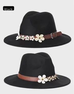 Dettaglio cappello in feltro nero con fascia in cuoio e cinque piccoli fiori bianchi