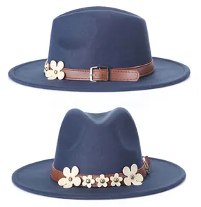 Dettaglio di un fedora blu navy con fascia in pelle marrone e fiori bianchi