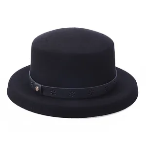 Flat top black wool fedora with floral leather band and gold buckle on white background