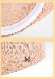 Close-up of woven straw hat interior lining and black metal M letter logo detail