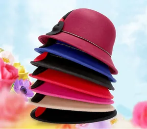 Dettaglio di cappelli cloche in lana multicolore con fasce di perline e fiocchi laterali