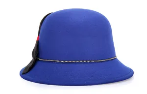 Dettaglio cappello cloche in lana blu reale con catena dorata e fiocco nero chic