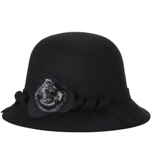 Elegante cappello cloche nero in lana da donna con fiore laterale e pompon di pelliccia
