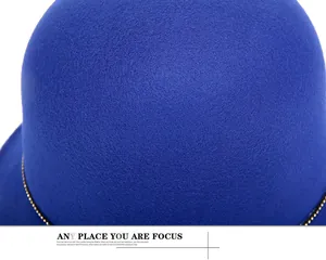Dettaglio cappello in feltro blu reale con elegante catena dorata sulla tesa del cappello