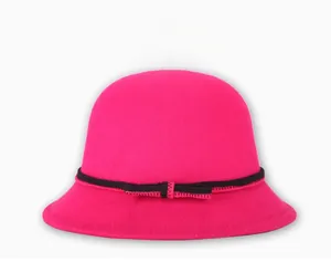 Detail of wool cloche hat in vibrant fuchsia with a black knitted bow decoration