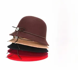 Detail of wool felt cloche hats featuring elegant rhinestone flower buckles and bows