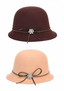 Close-up of wool cloche hats in coffee and camel colors with rhinestone bow detail