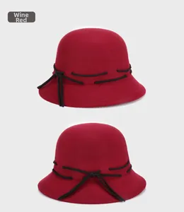Detail of wine red wool felt bowler hat with a delicate black ribbon bow decoration