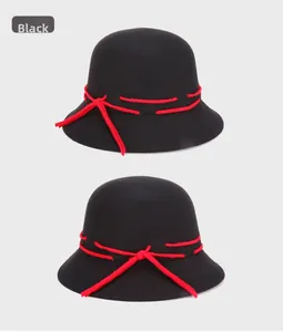 Close-up of black wool fedora bucket hat featuring a distinctive red bow ribbon detail