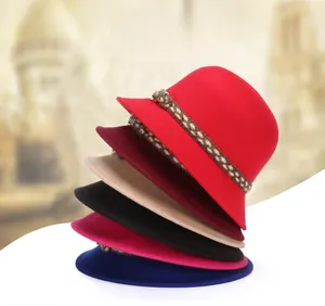 Pila verticale di cappelli in lana da donna in vari colori con eleganti cinturini intrecciati