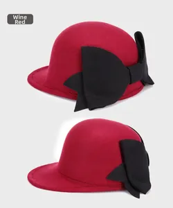 Side view of wine red wool felt bowler hat with a large black bow for elegant style