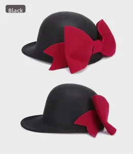 Close-up of a black wool felt bowler hat featuring a large elegant red bow detail