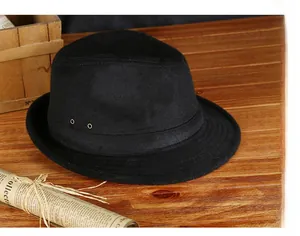 Detail of vintage black wool fedora featuring three metal grommets on wooden table