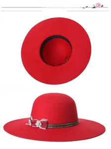 Detail view of red wide brim wool hat with lace floral trim and gold chain accents